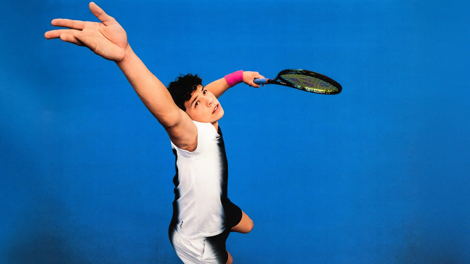 Ben Shelton winds up to serve a tennis ball.