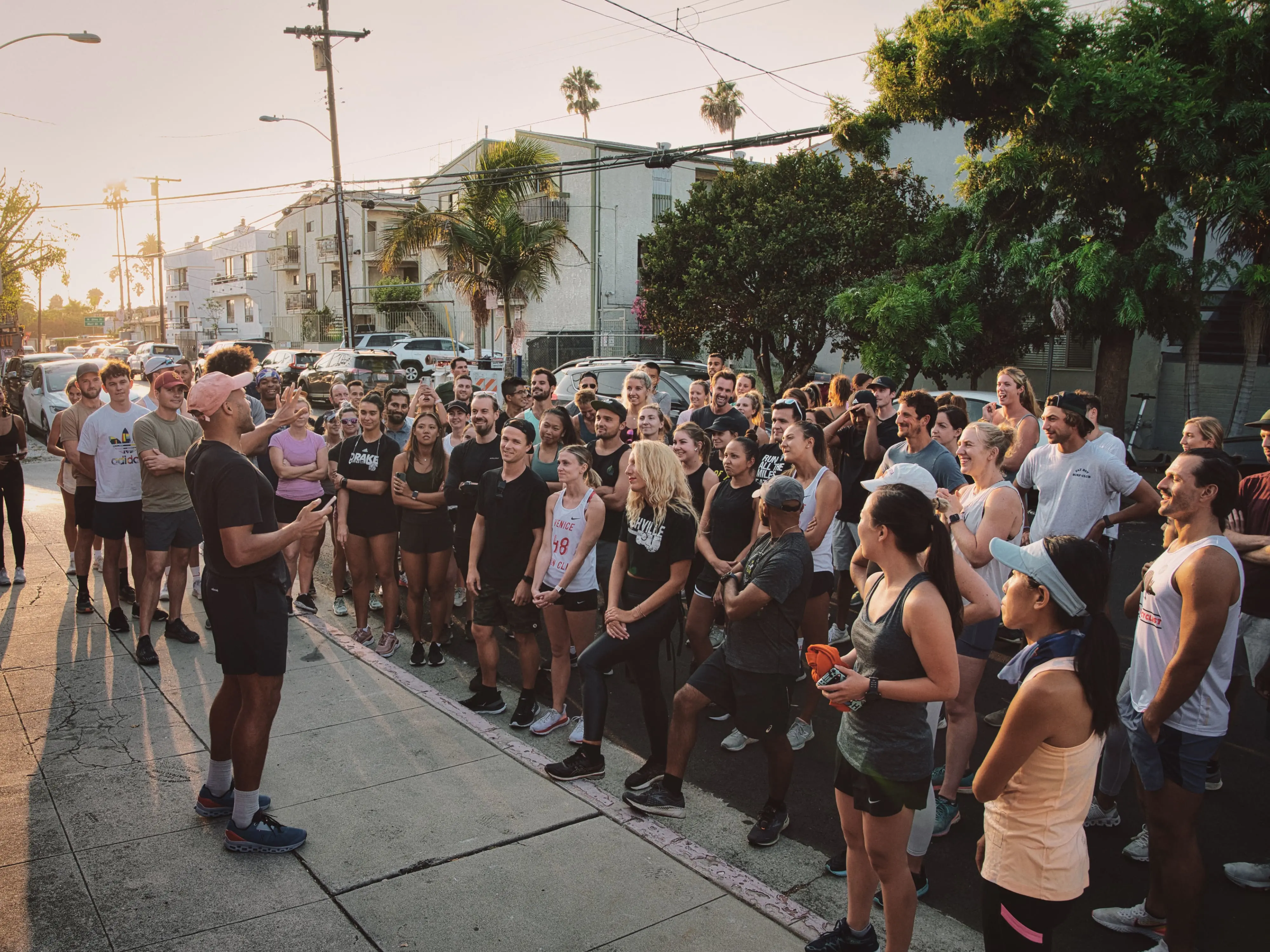 man speaking to a crowd of runners