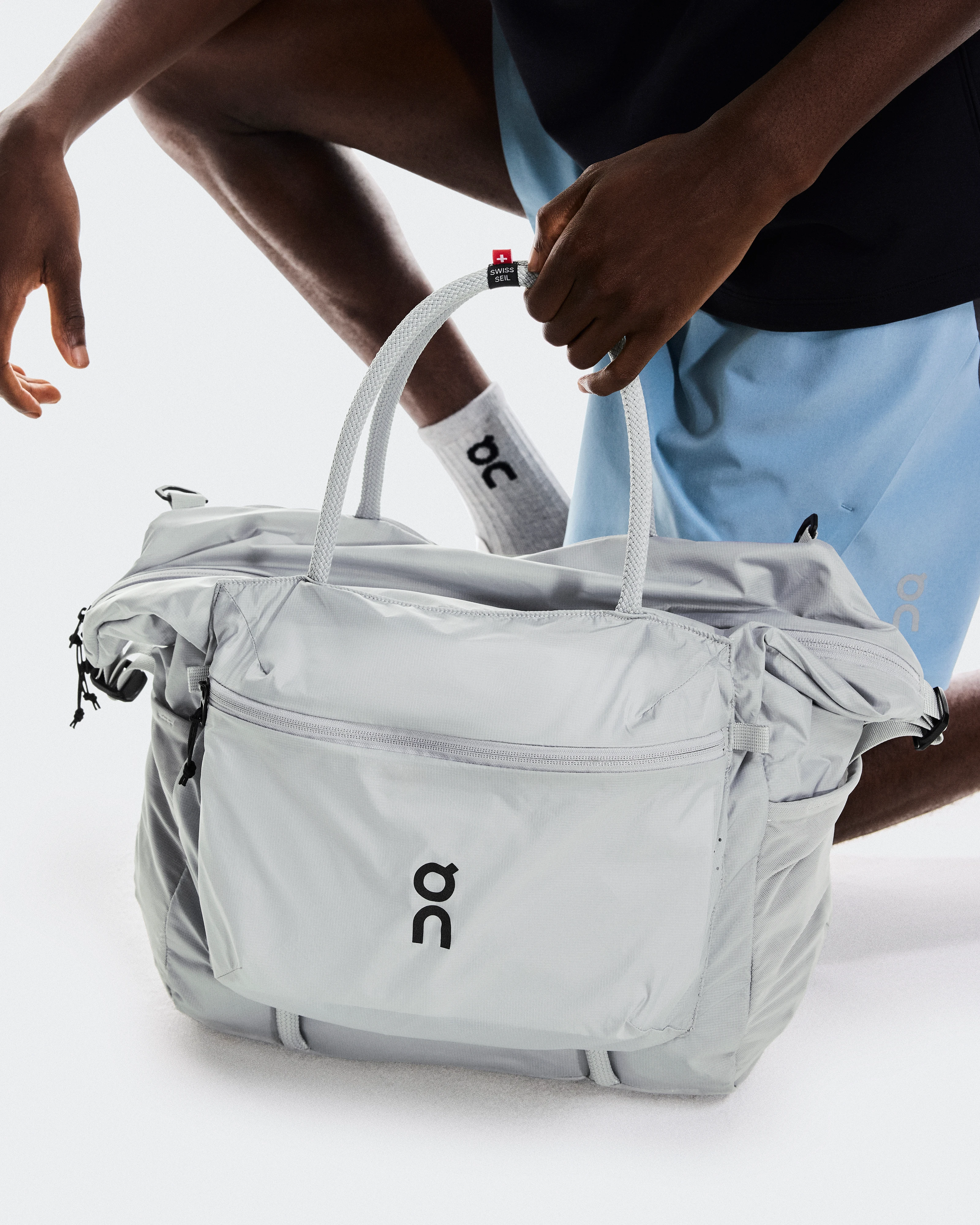 Person picking up their On gym bag.