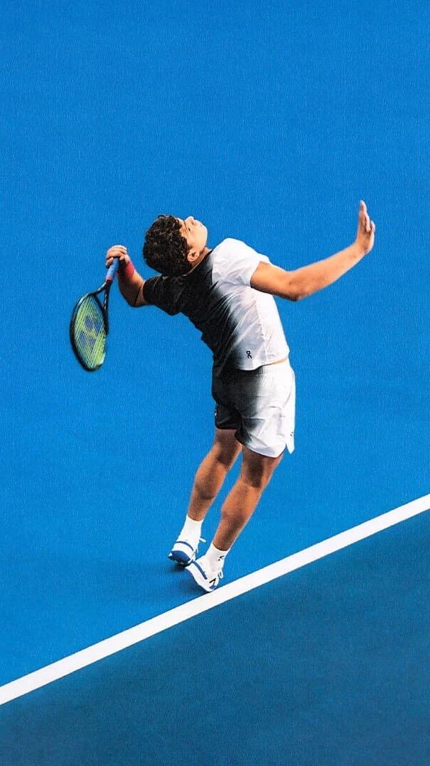 Ben Shelton is in his backswing as he prepares to serve the ball.