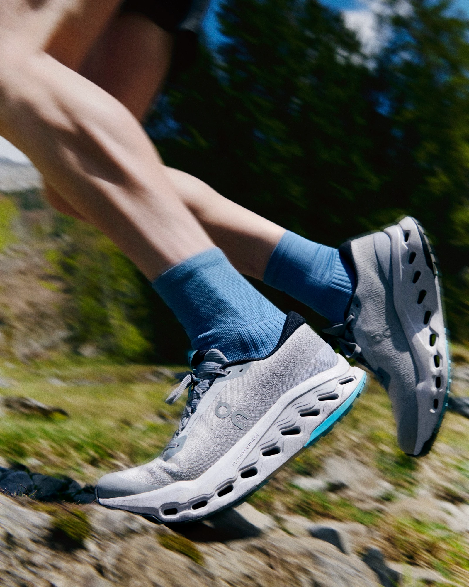 Close-up of On running shoes on a rocky mountain trail.