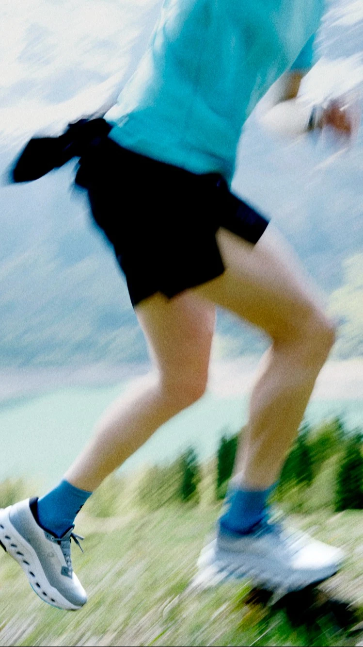 Blurred image of a runner running on a mountain trail.