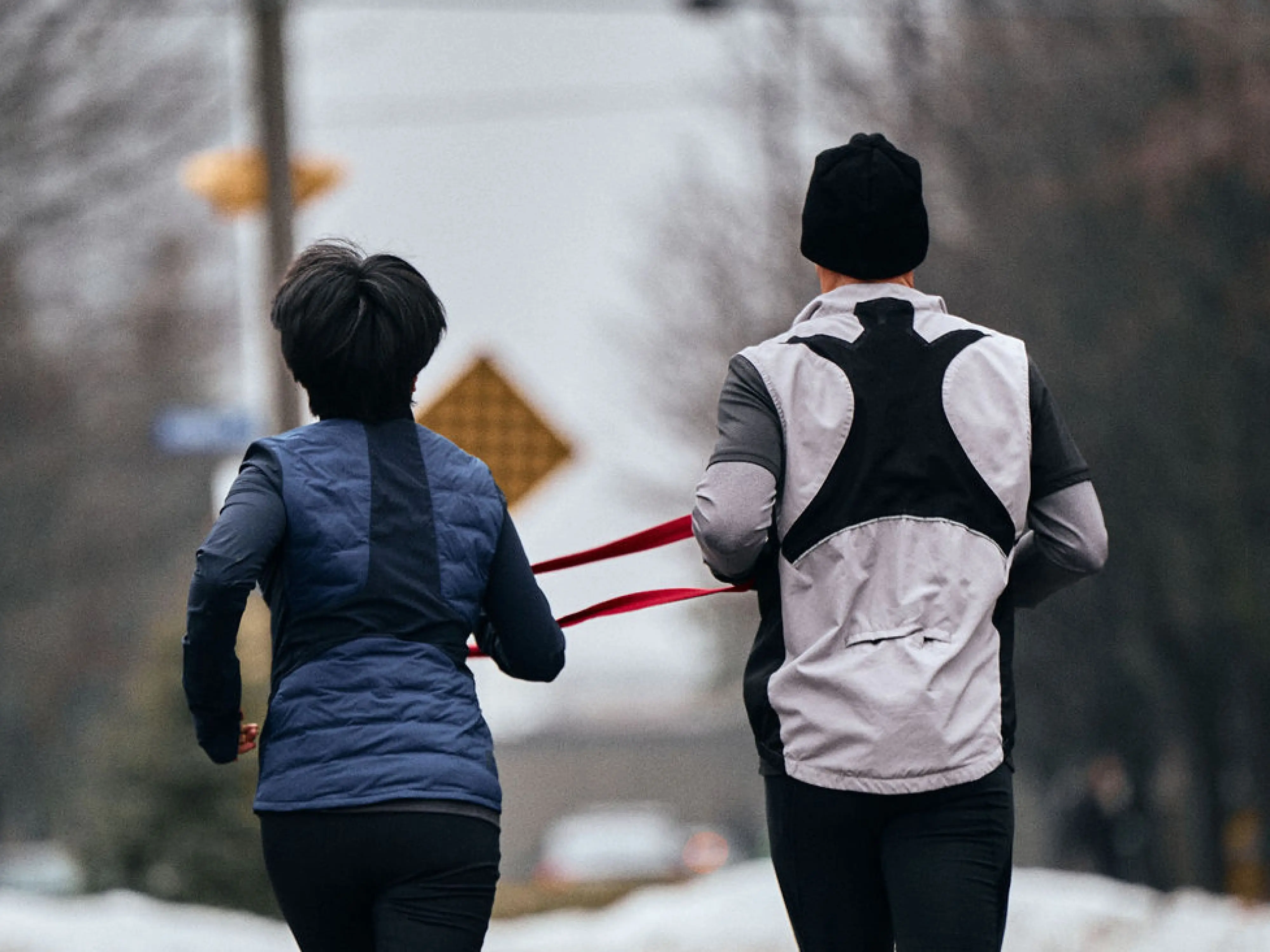 two athletes with disabilities running with rope guide