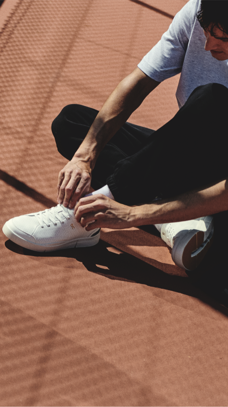 Two people try on their tennis shoes to see how they fit.