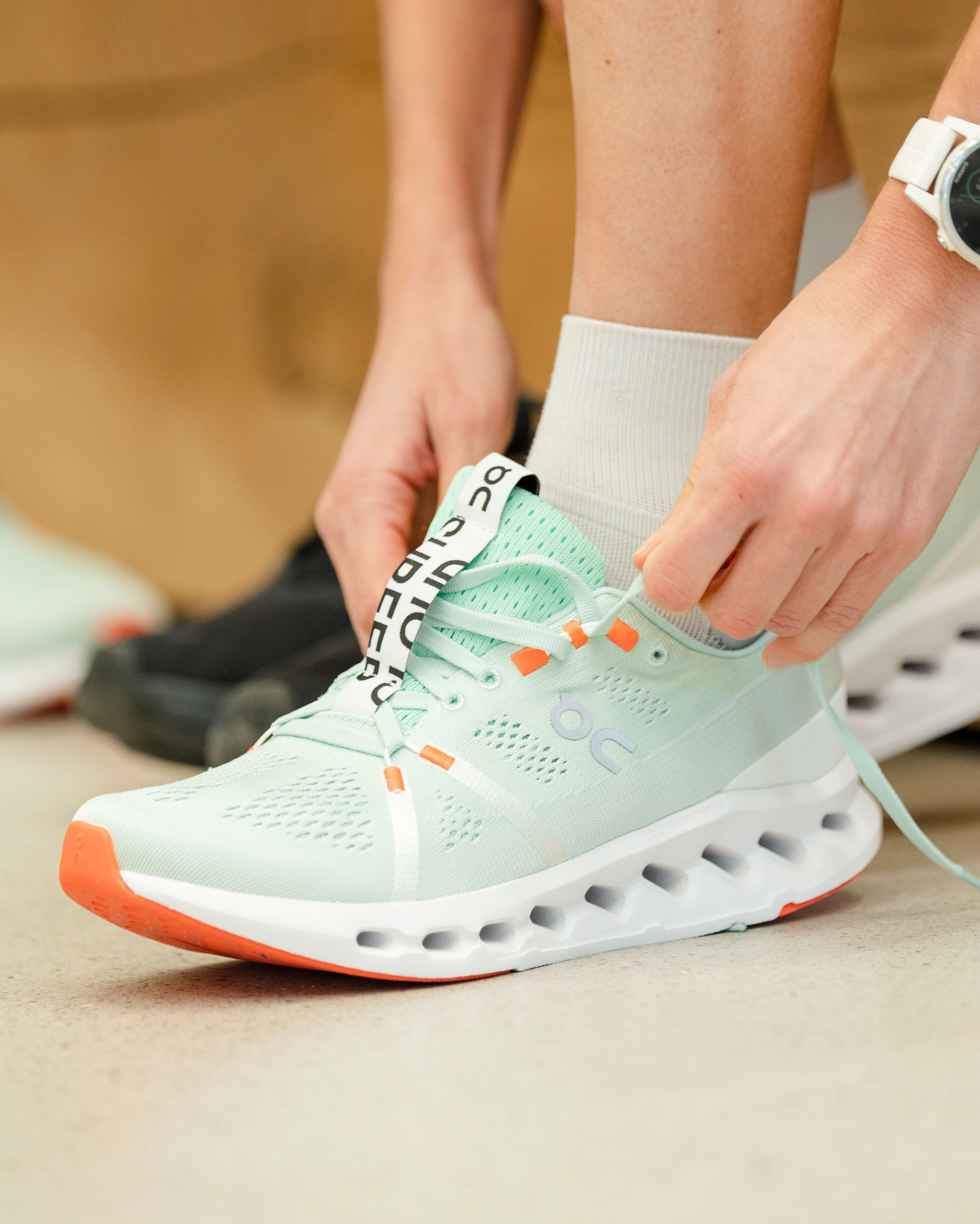A runner putting on the all-new Cloudsurfer.