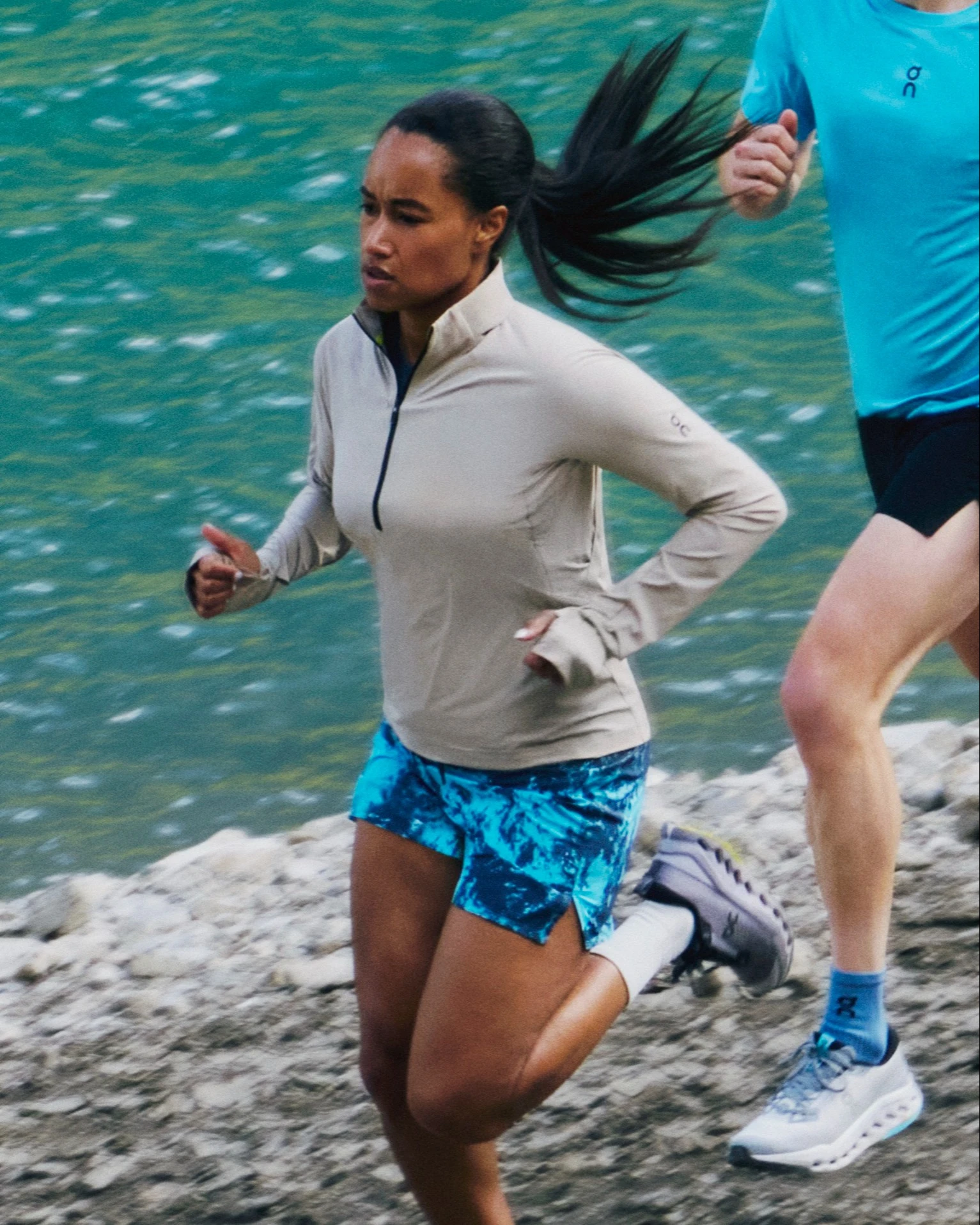 Two runners running alongside a waterfront.