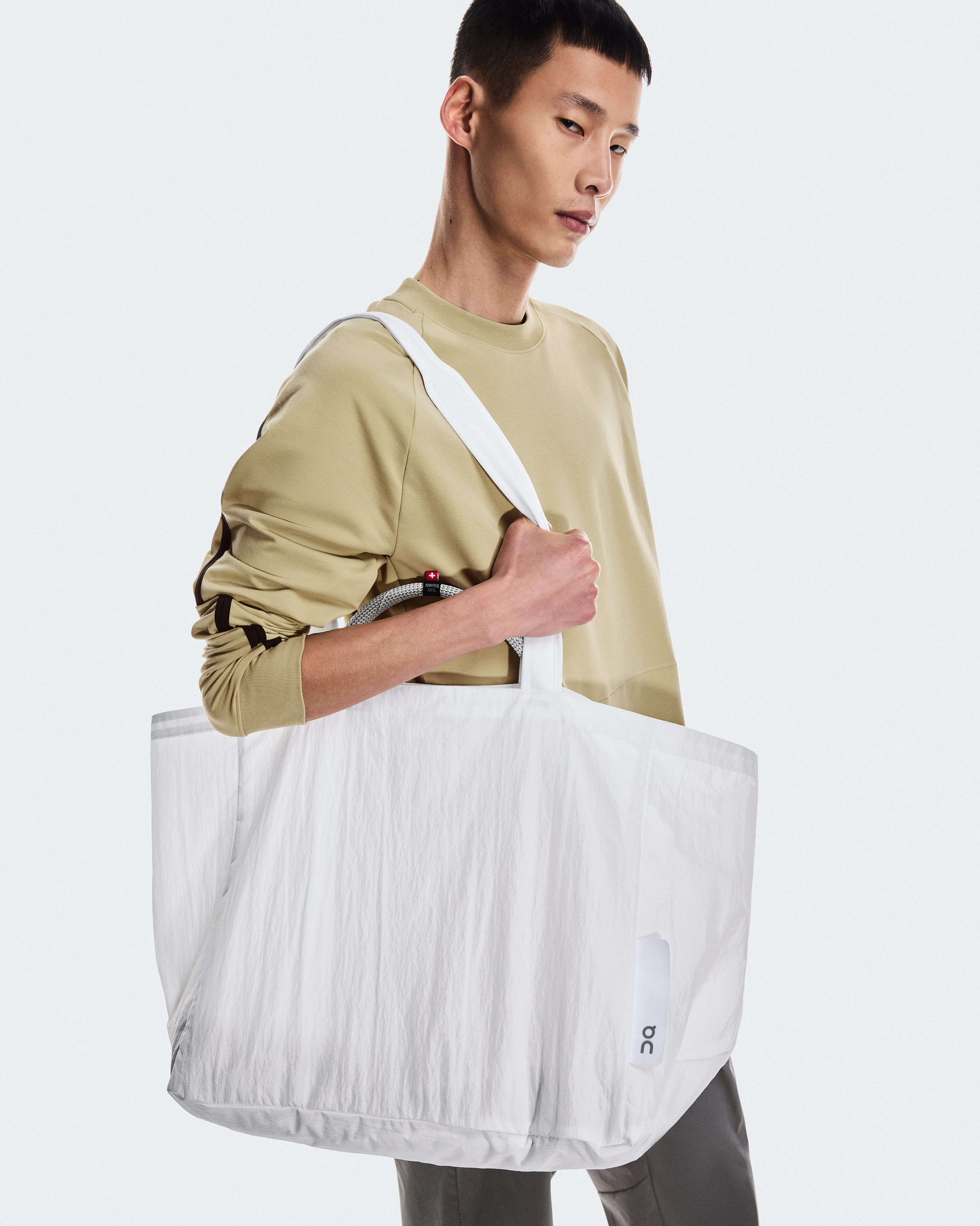 Man carrying an On bag over his shoulder.