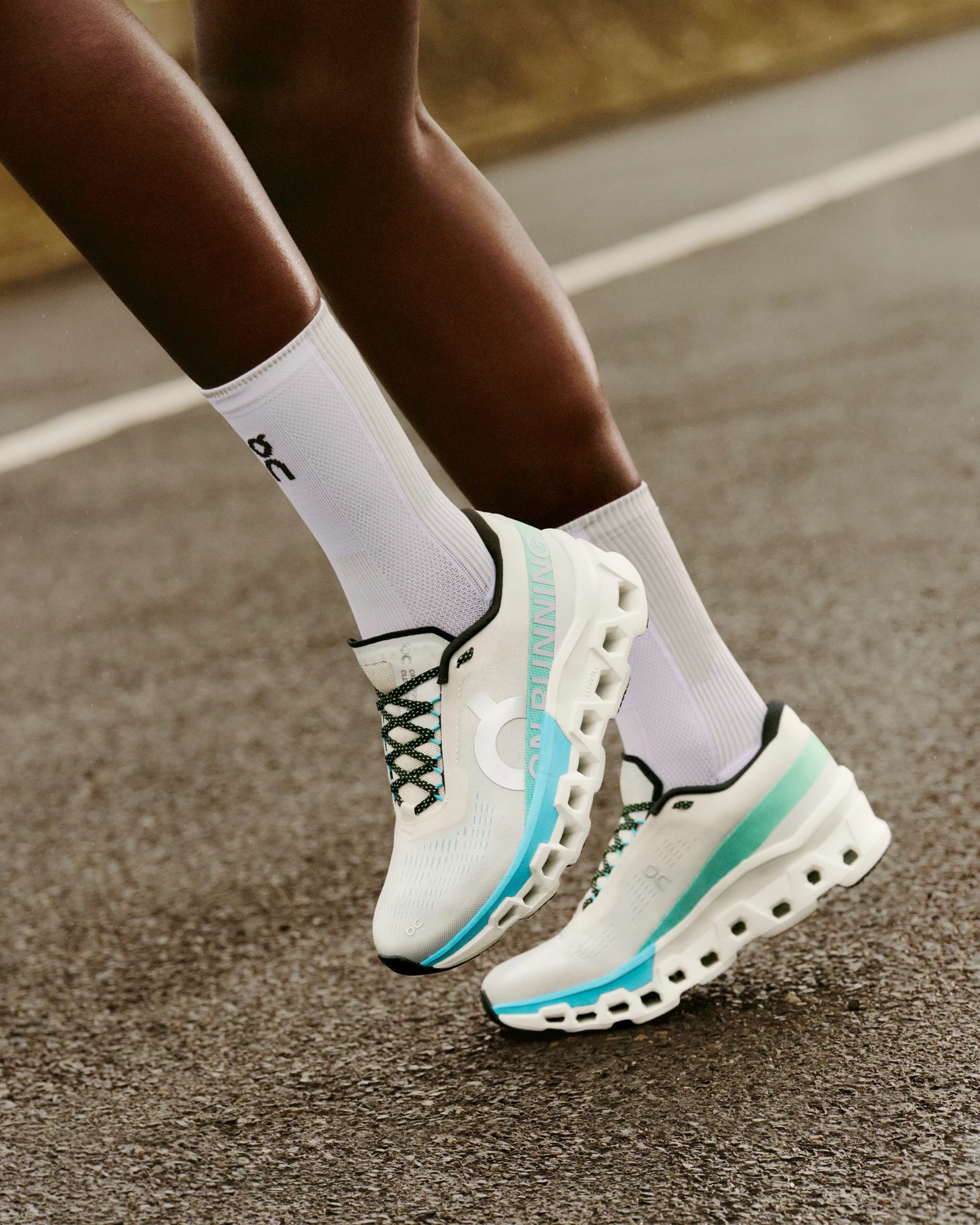 Person wearing On Cloudmonster 2 running shoes while warming up for a run.