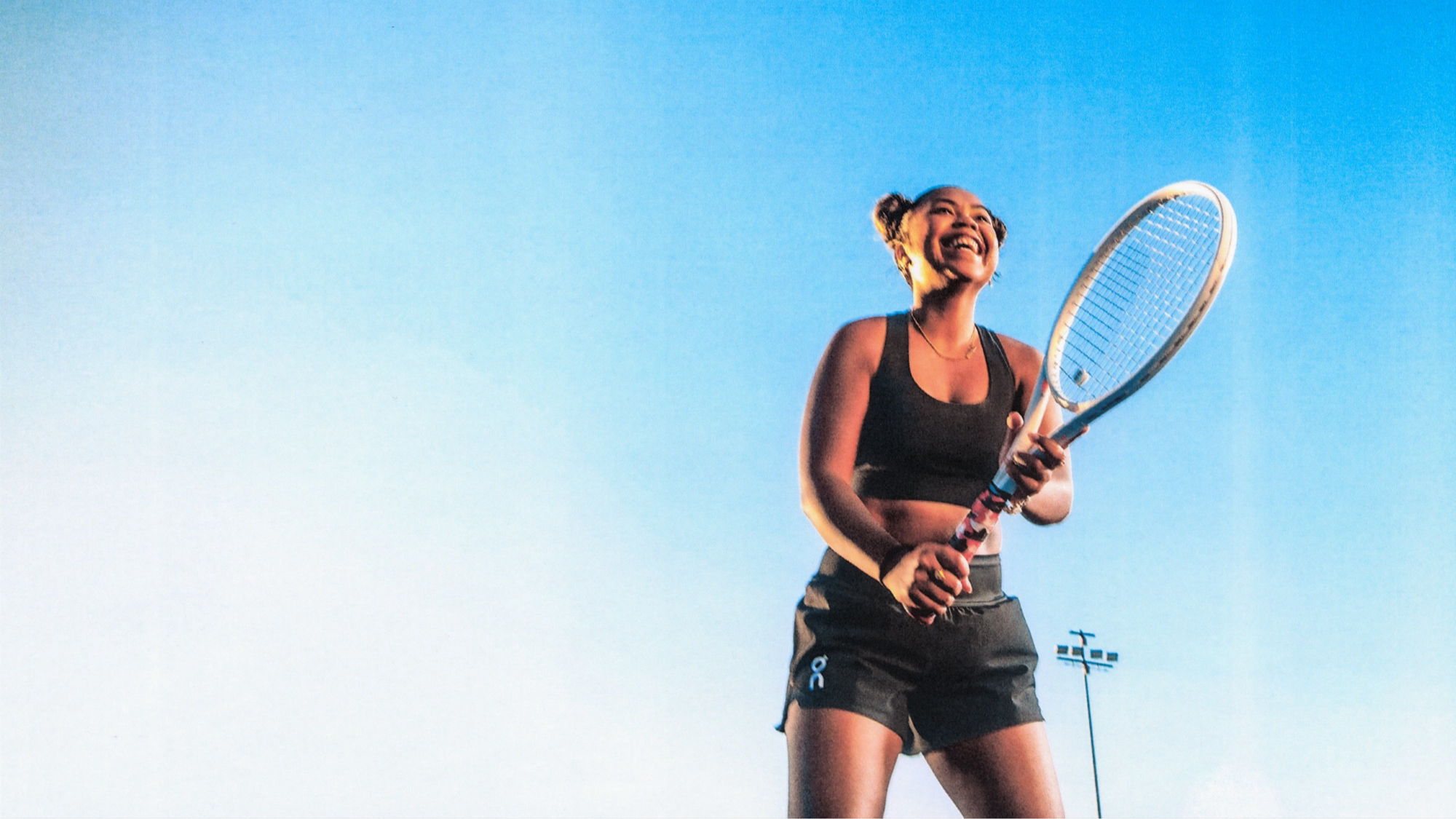 A smiling tennis player takes a moment to appreciate her performance in the match.