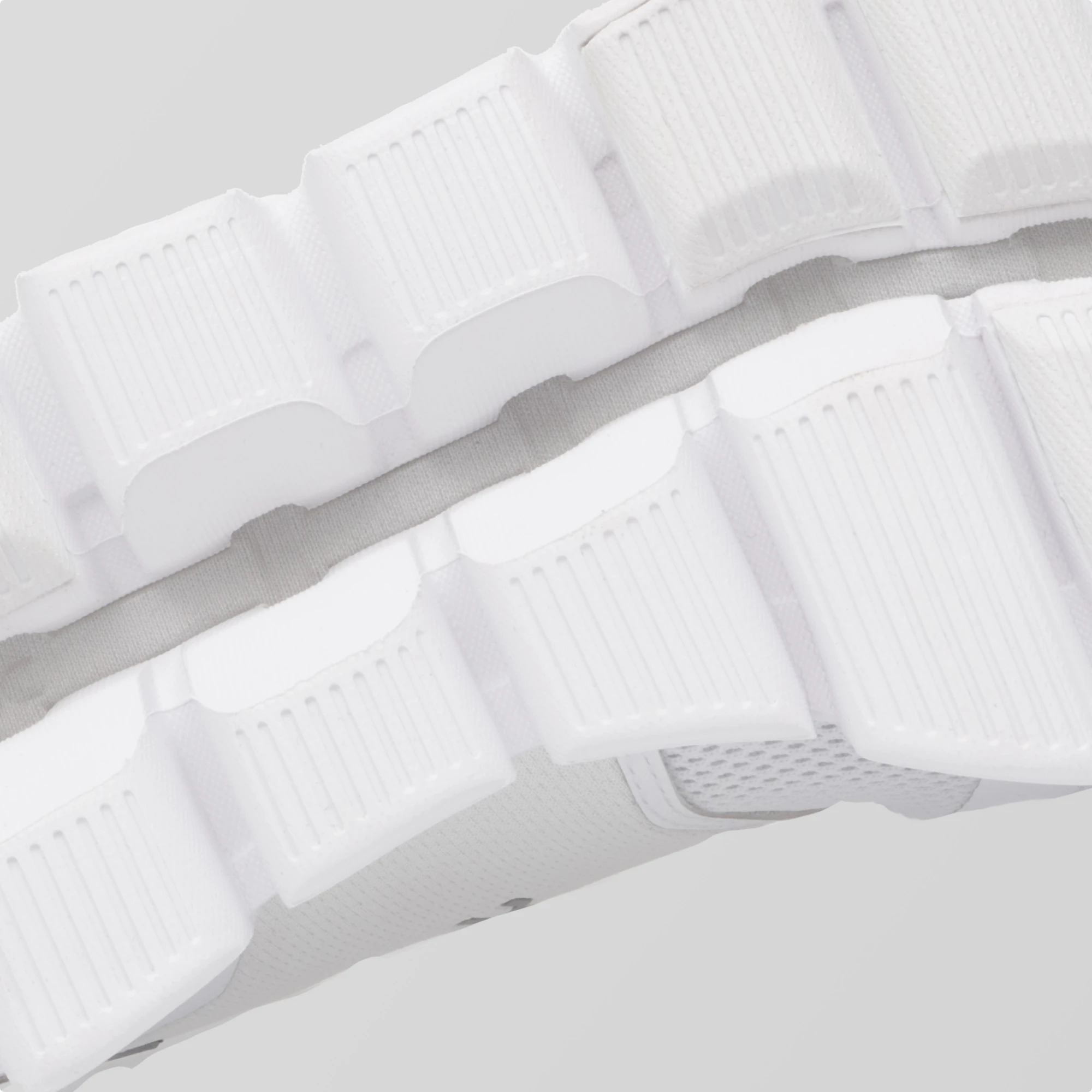 Close-up of a CloudTec outsole in white against a gray backdrop. 