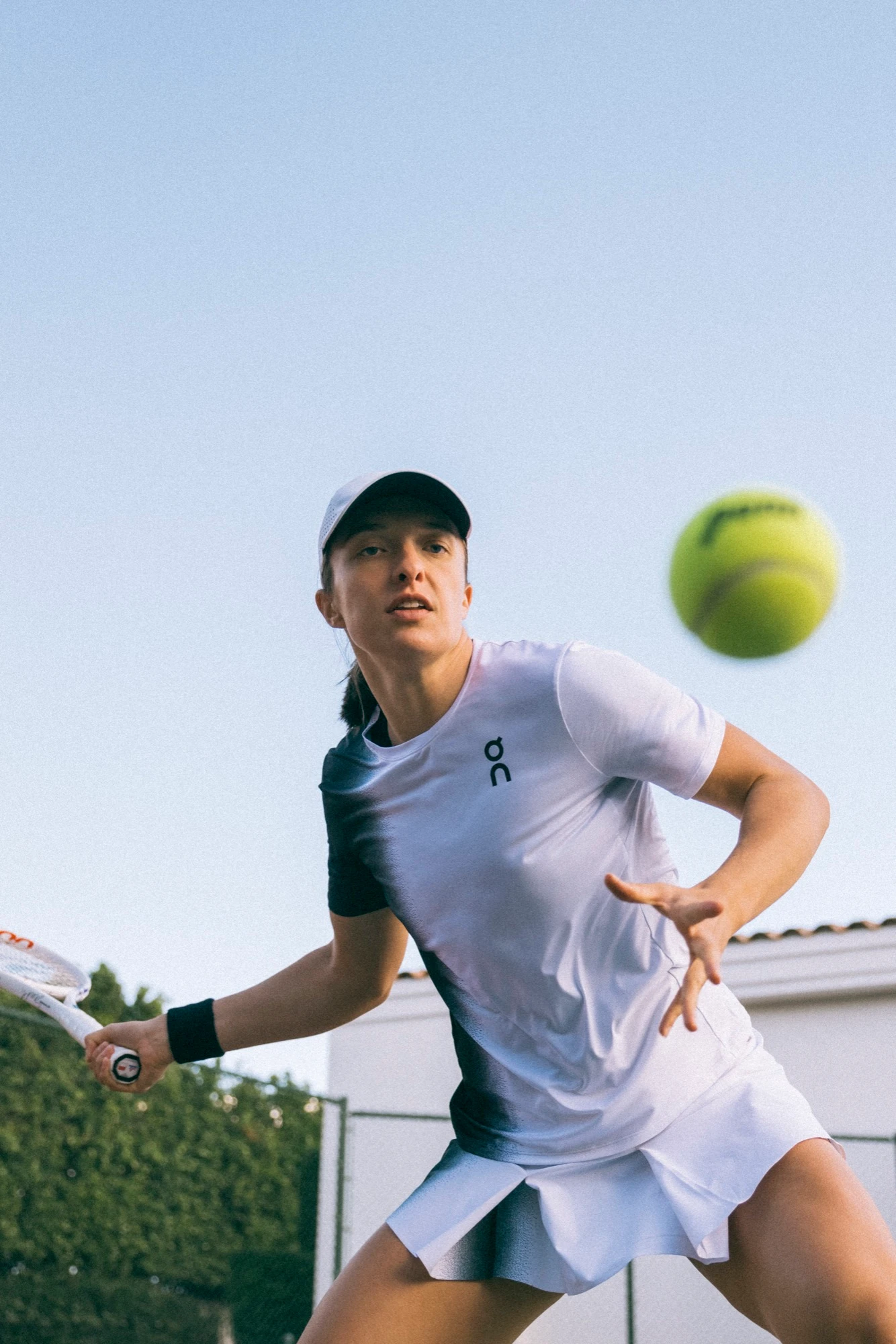 Iga Świątek swings through her tennis forehand and finishes high. 