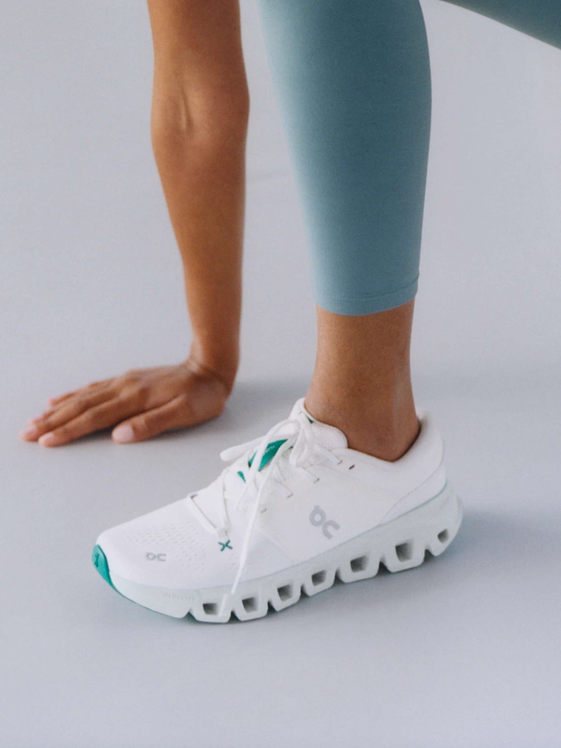 Knee-down view of a woman standing in the Cloudprime, a CleanCloud shoe.