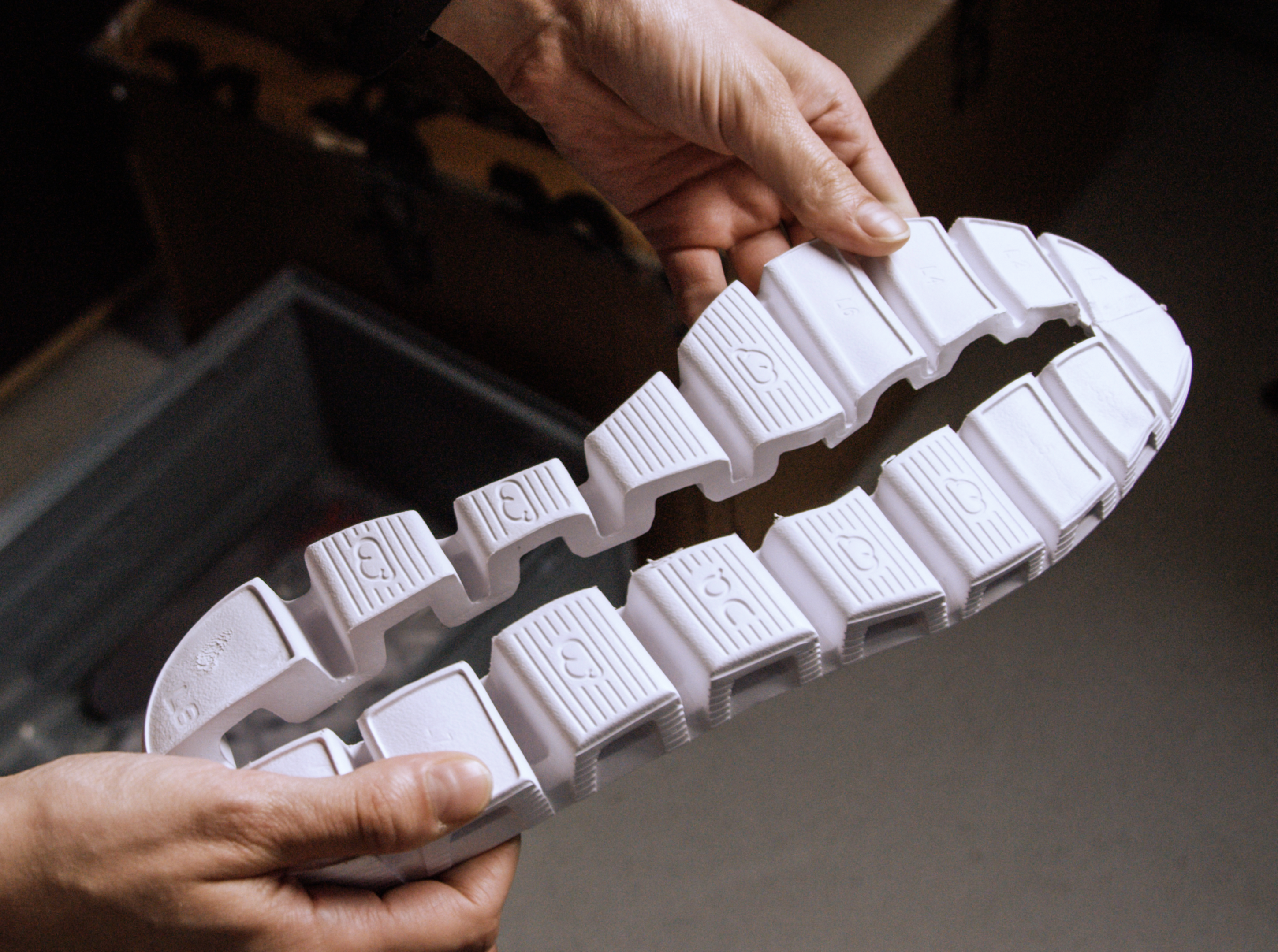 Close up of hands holding a CloudTec outsole.