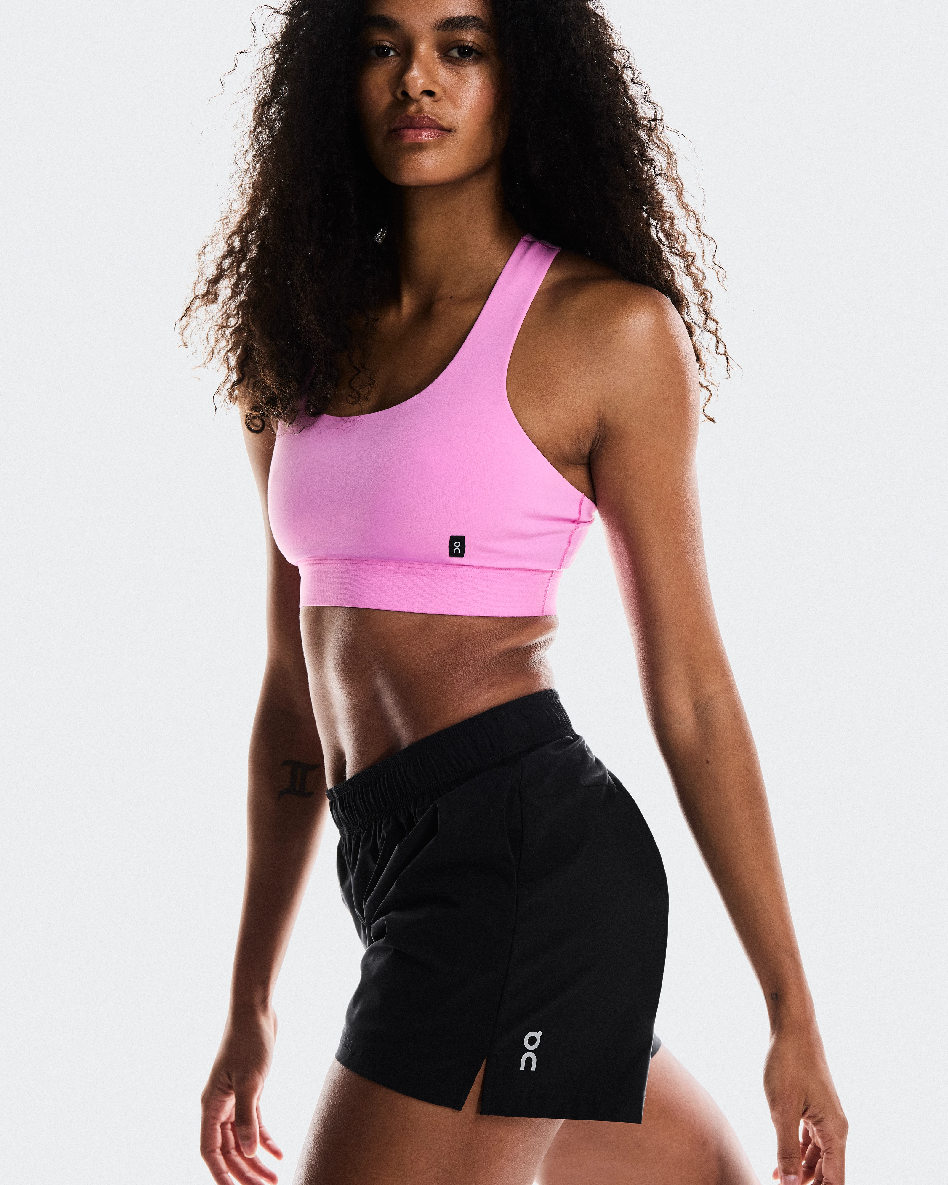 Woman wearing shorts and a supportive sports bra for a workout session.