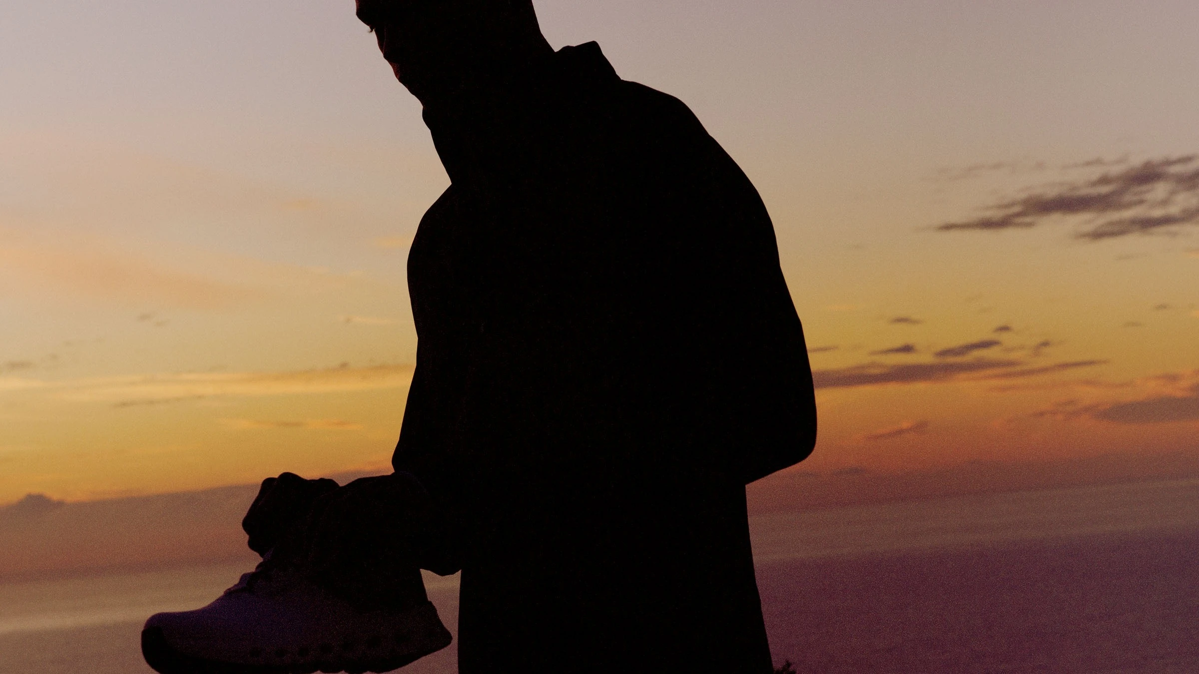 A man puts on his shoes before a sunset run.