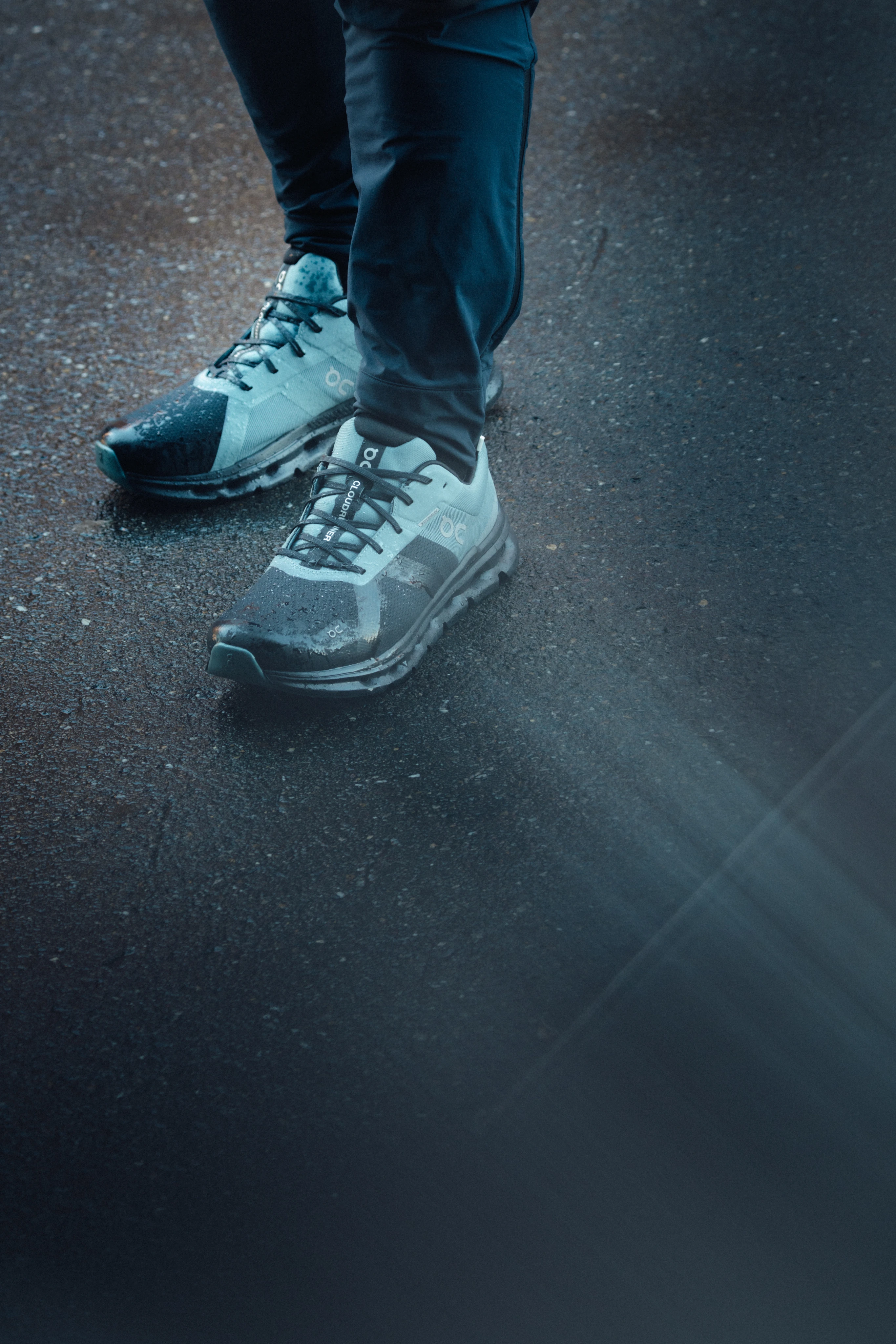 Close-up of the Cloudrunner Waterproof in blue against an asphalt road.
