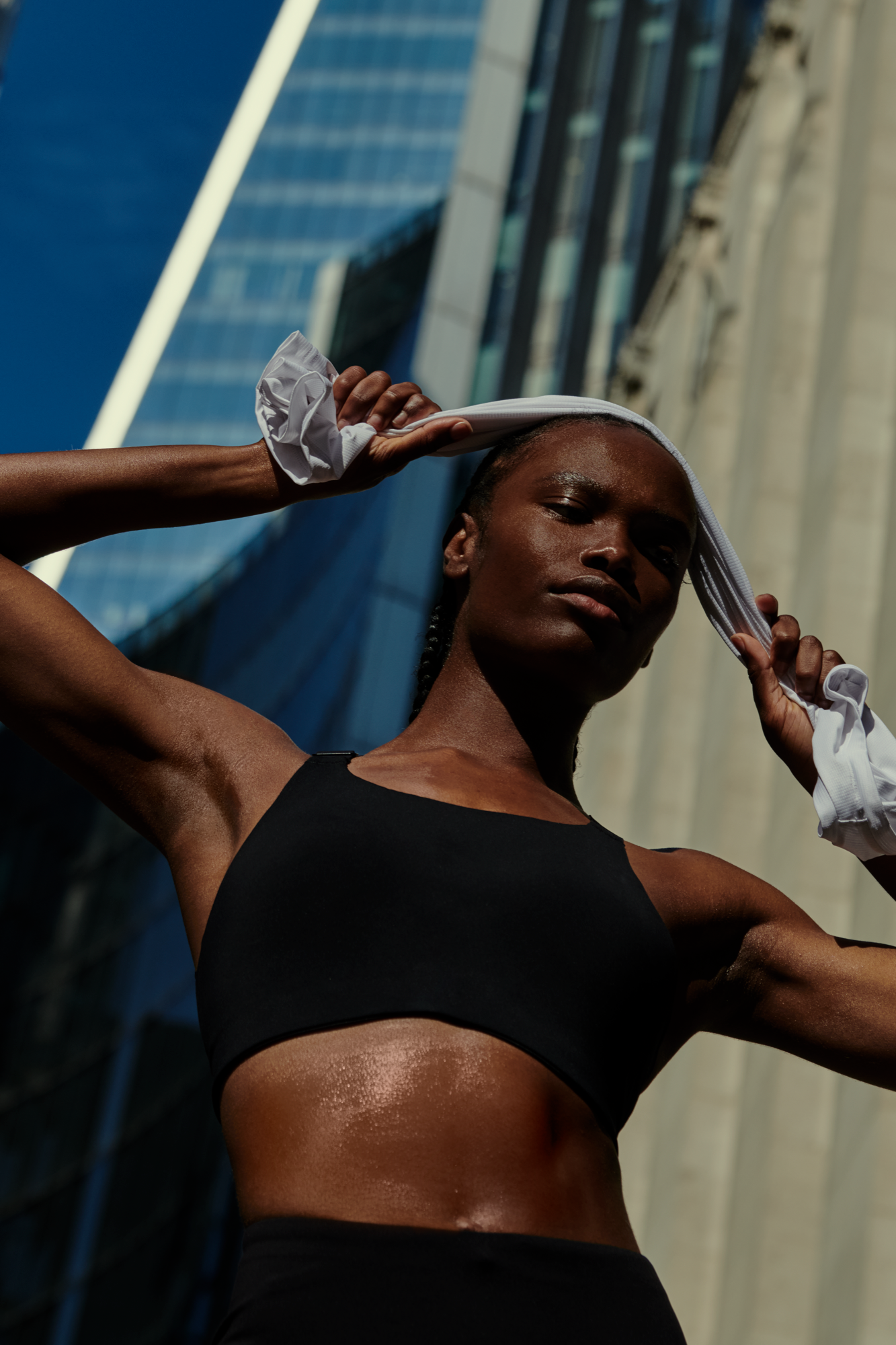 A woman wipes sweat from her forehead after an outdoor workout.