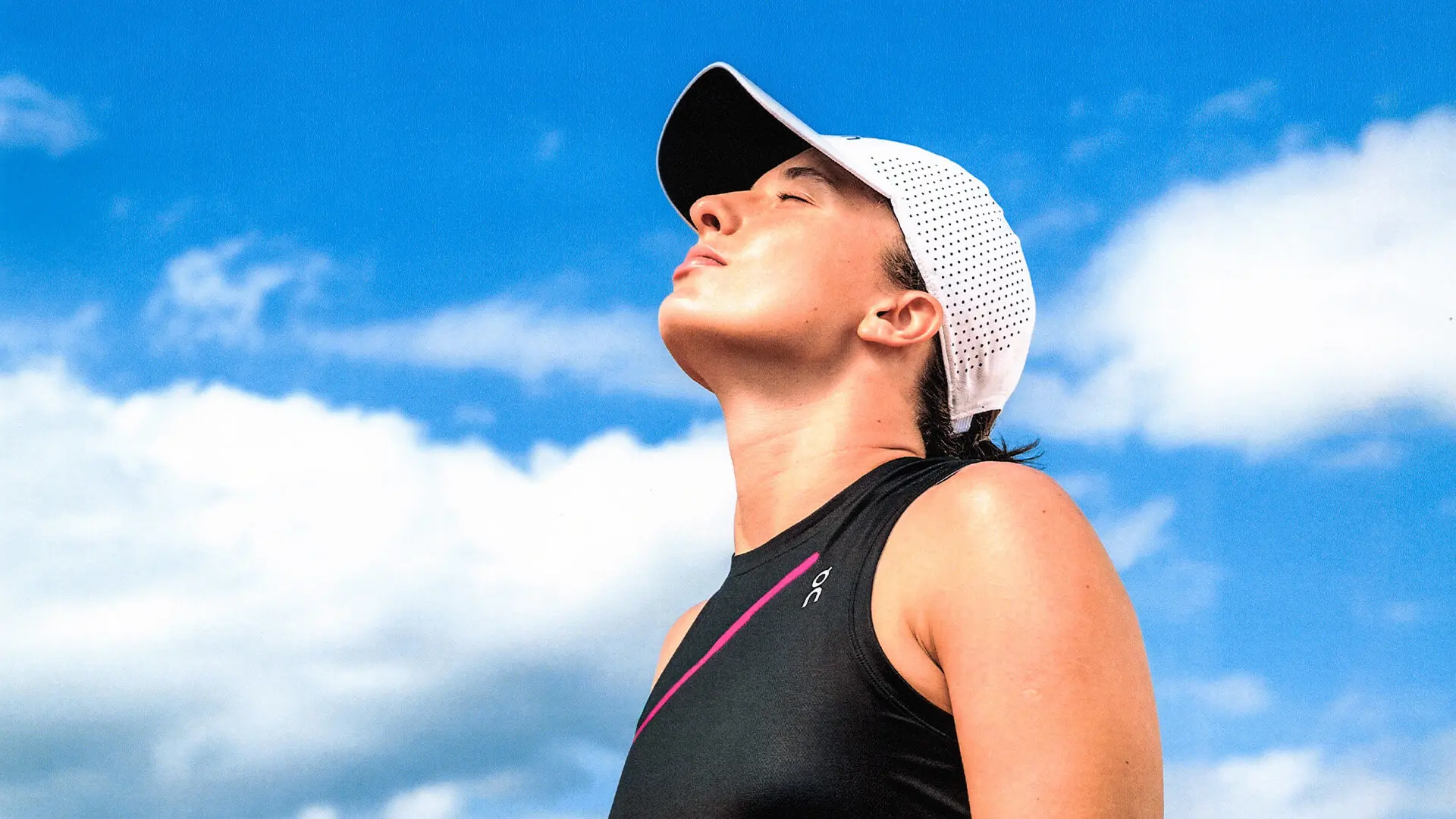 Iga Świątek in the On Court Tank and Court Cap looks toward the sky.