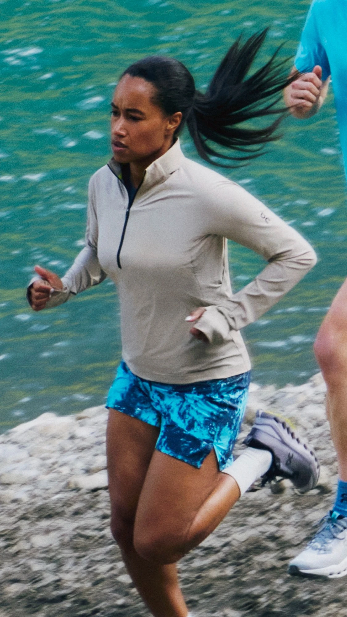 Two runners running alongside a waterfront.