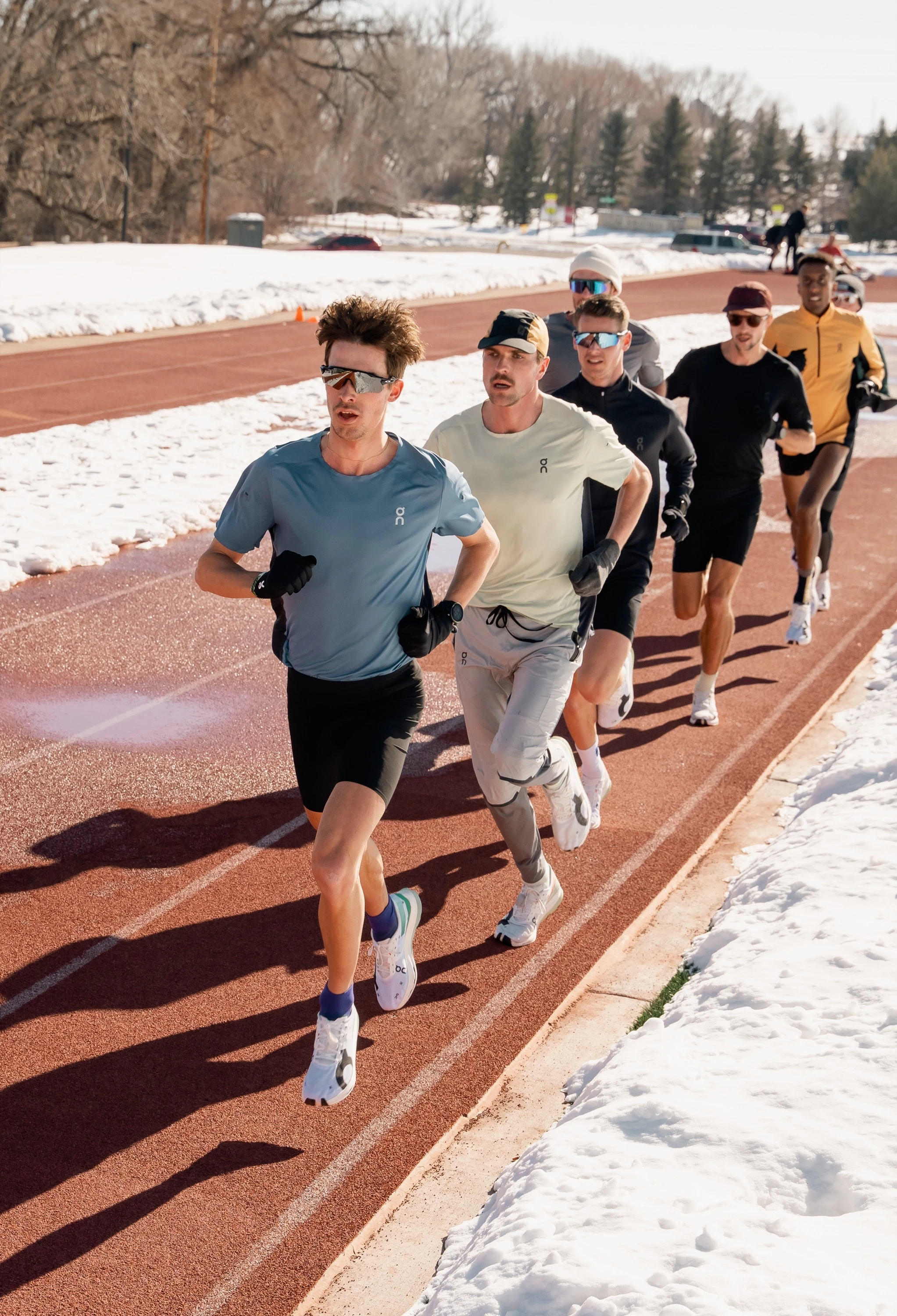 Athletes from our On Athletics Club, running on a snow-covered track.