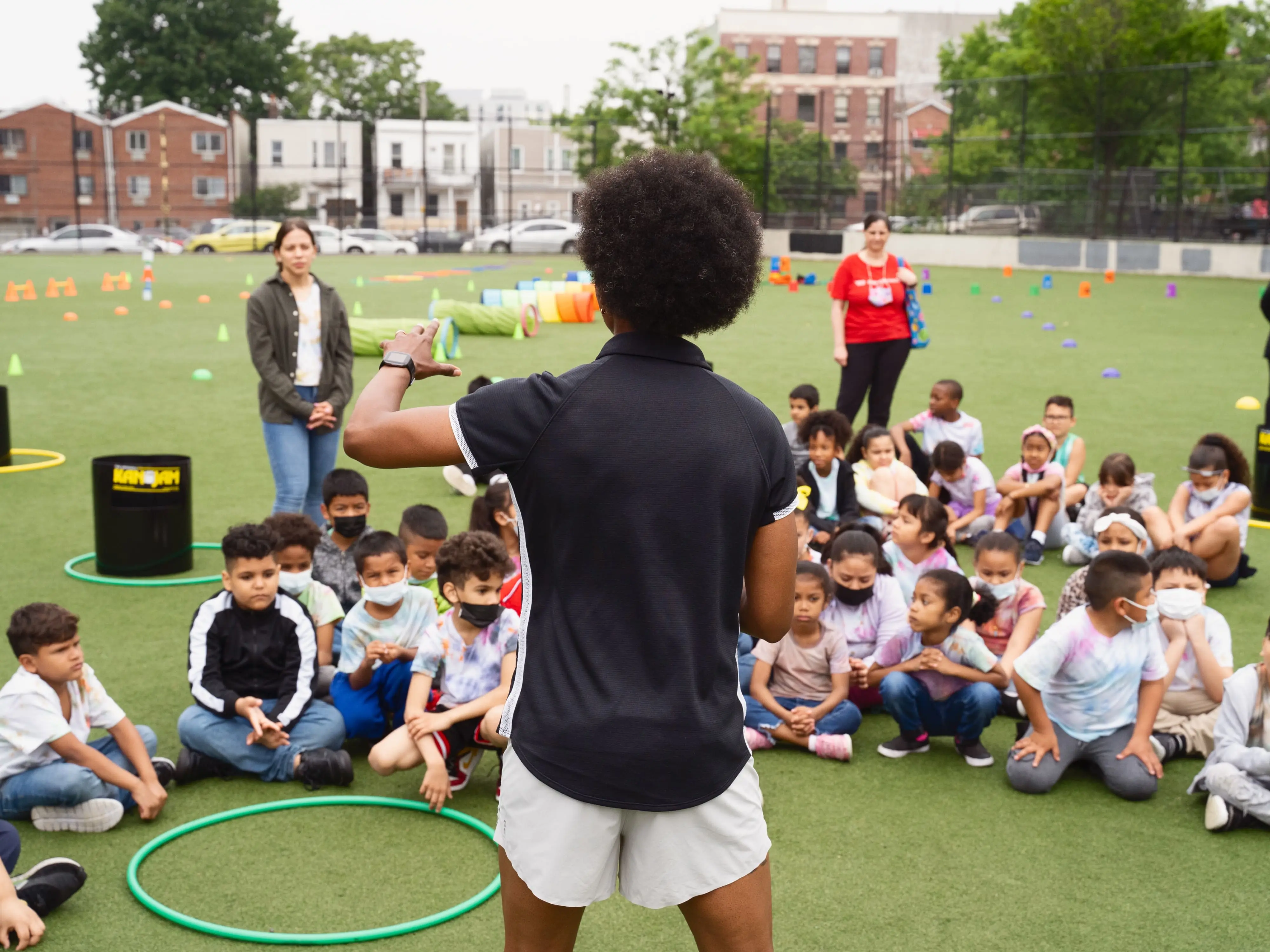 sports coach instructing group of children